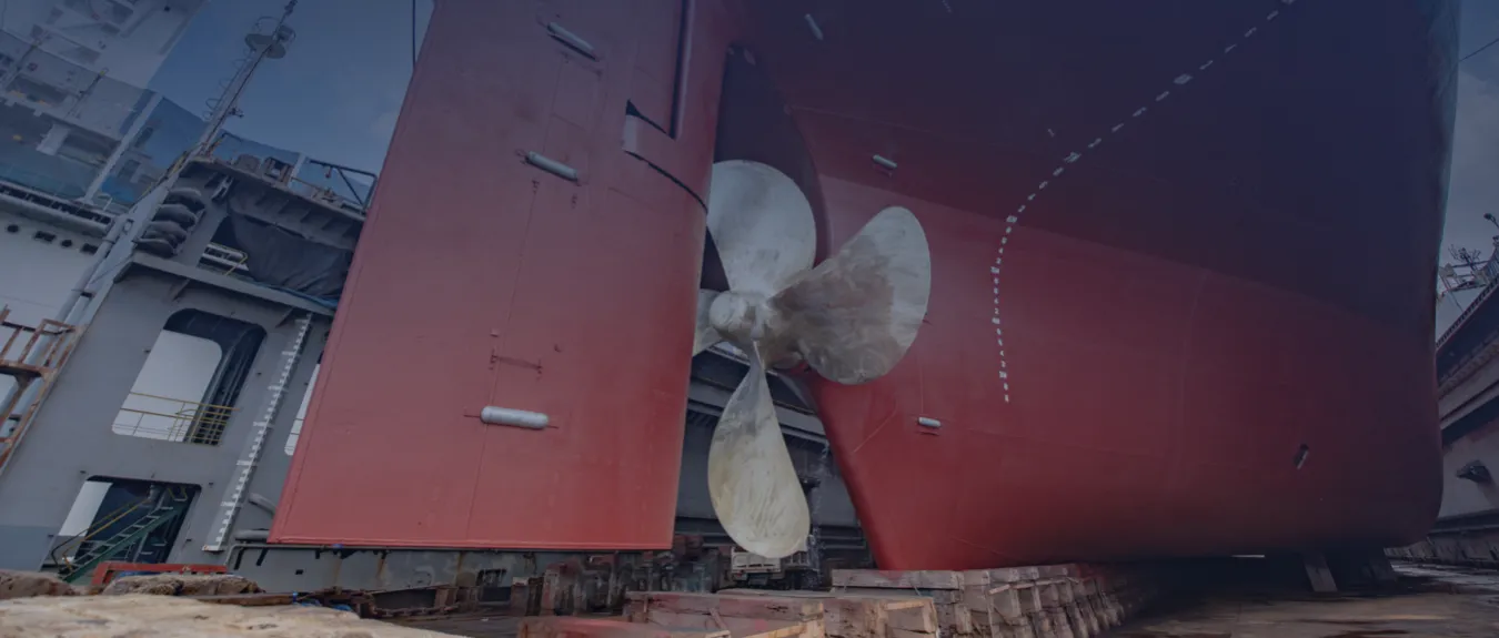 Ship propeller beneath the stern of a vessel during retrofit in drydock
